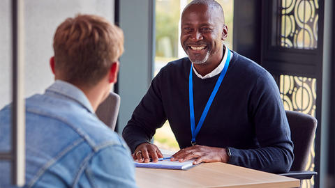 Man smiling welcoming a new employee