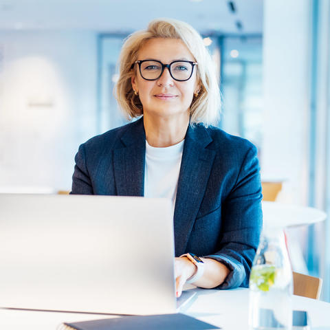Woman wearing glasses smiling at the computer