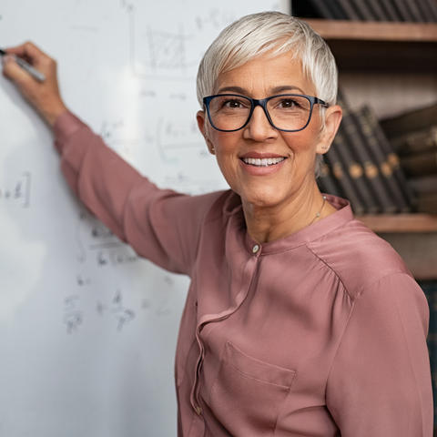 Woman faculty member at the while board