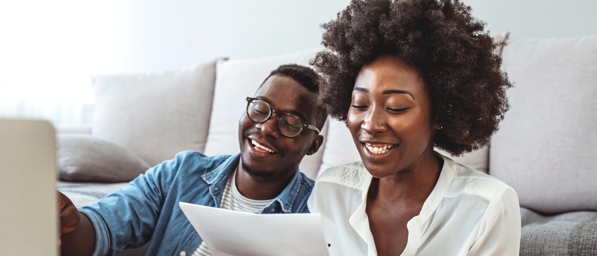 Woman and man smiling while looking over financial information
