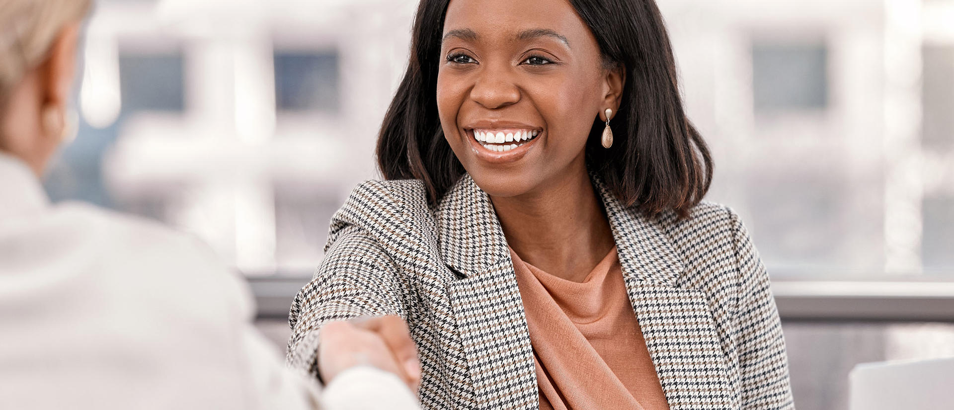 Woman smiling and shaking hands with her manager