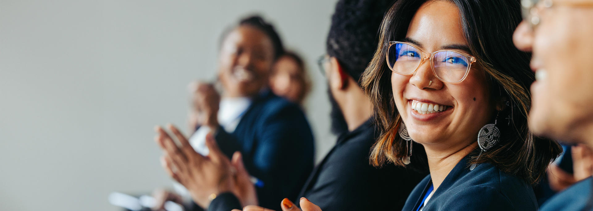 A row of people with a woman smiling in full focus