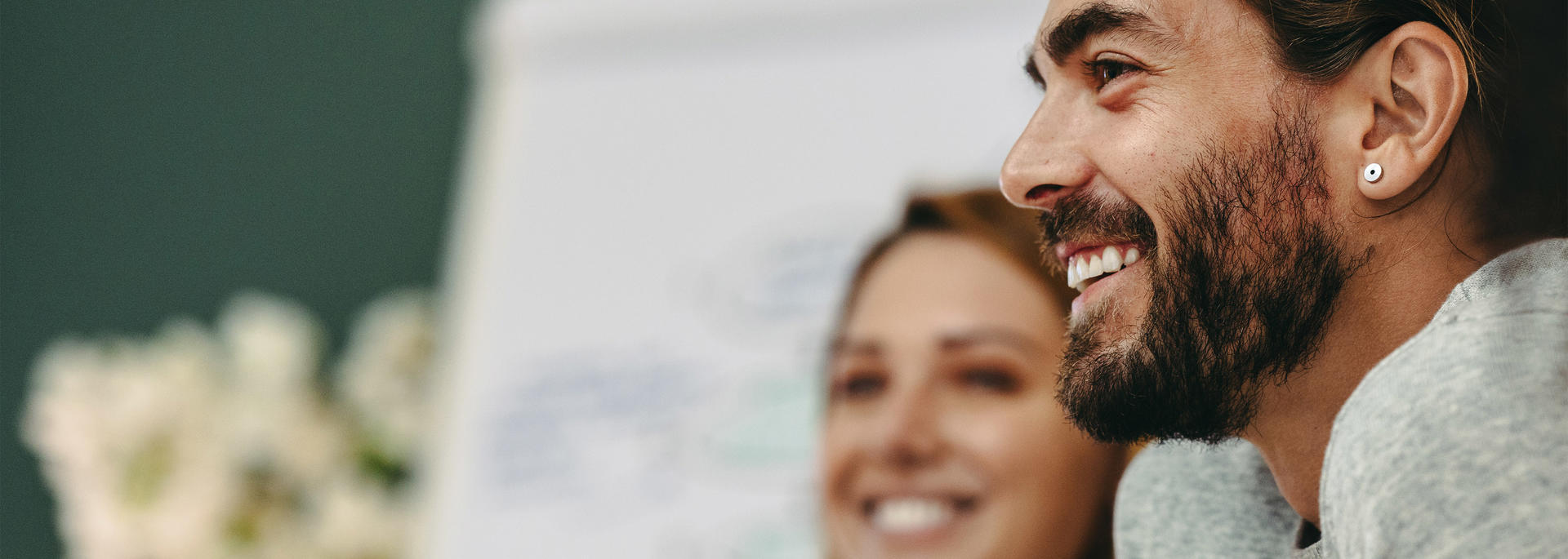 Man and woman sitting with other employees smiling
